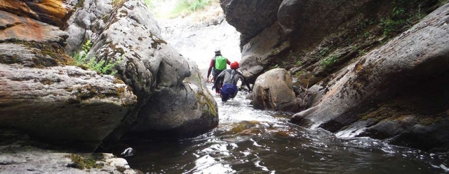 dos hombres recorriendo un cañón